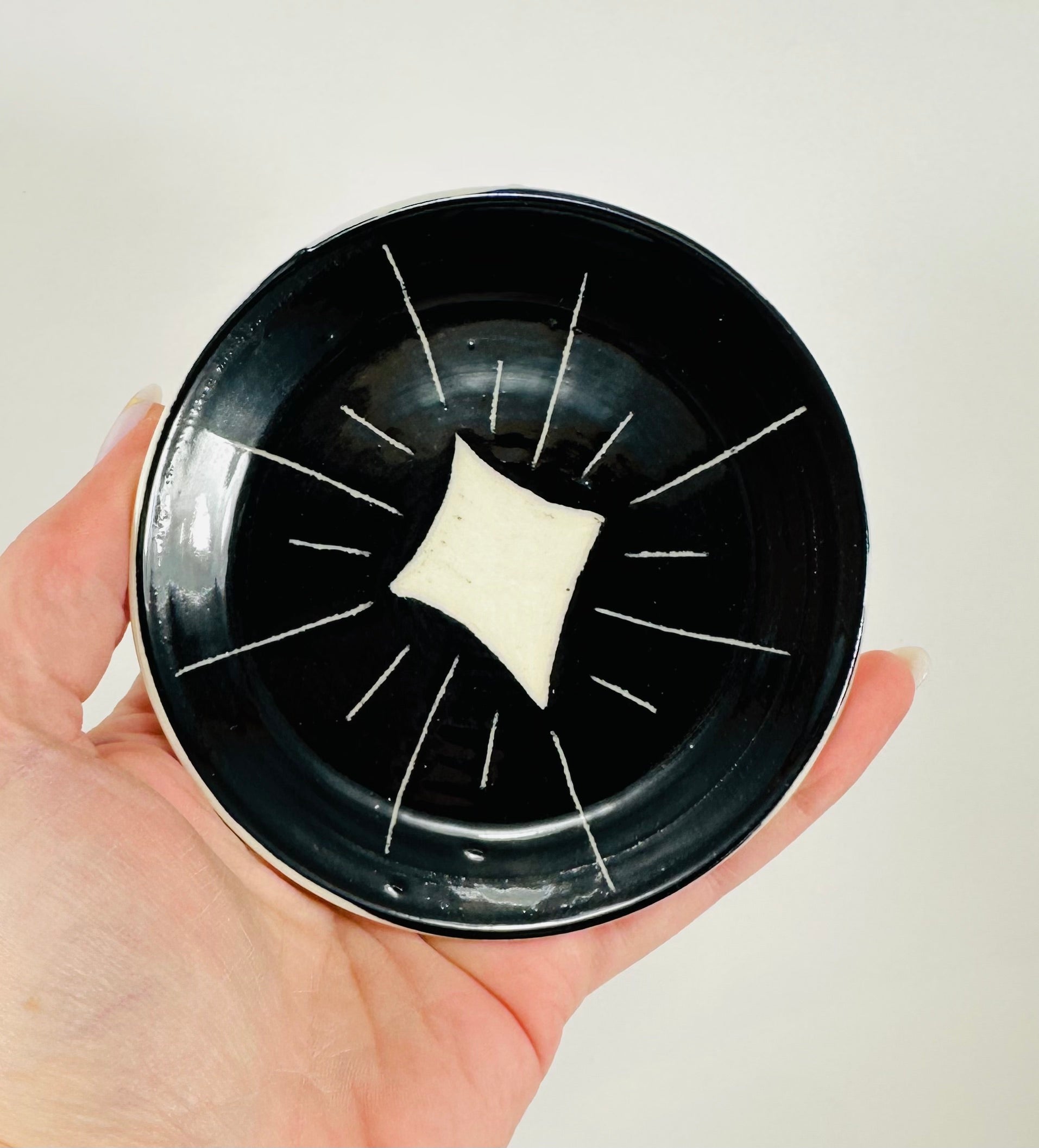 Handmade trinket dish in  black and white glaze with stars.