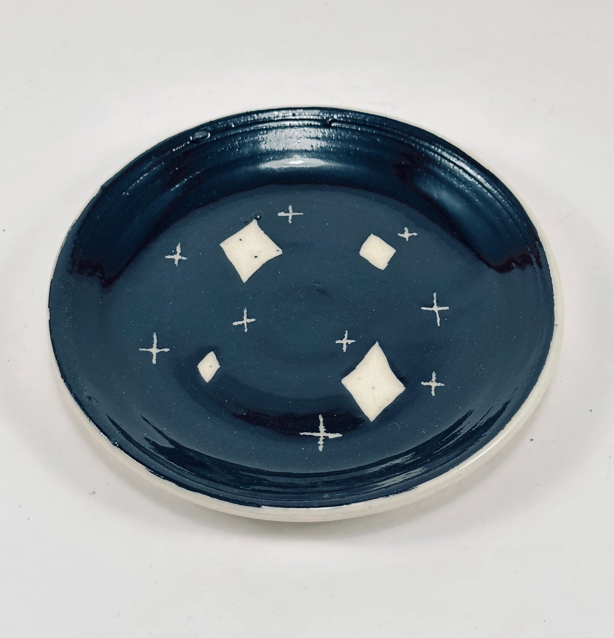 Handmade trinket dish in  black and white glaze with stars.