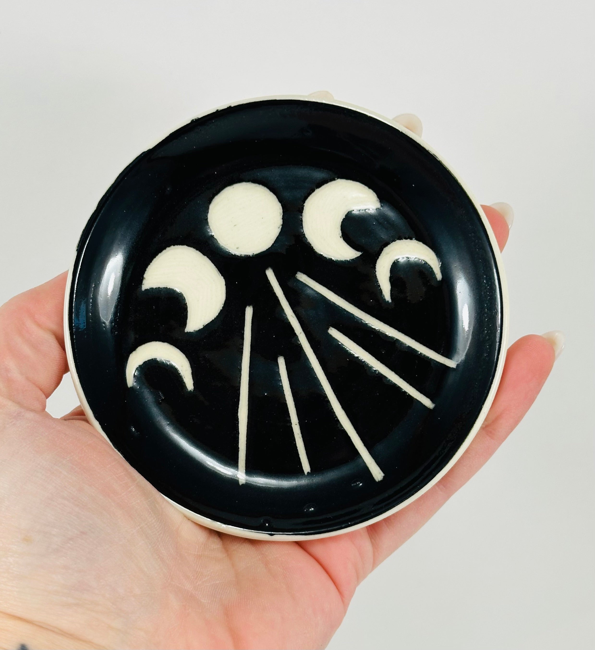 Handmade trinket dish in  black and white glaze with moons.