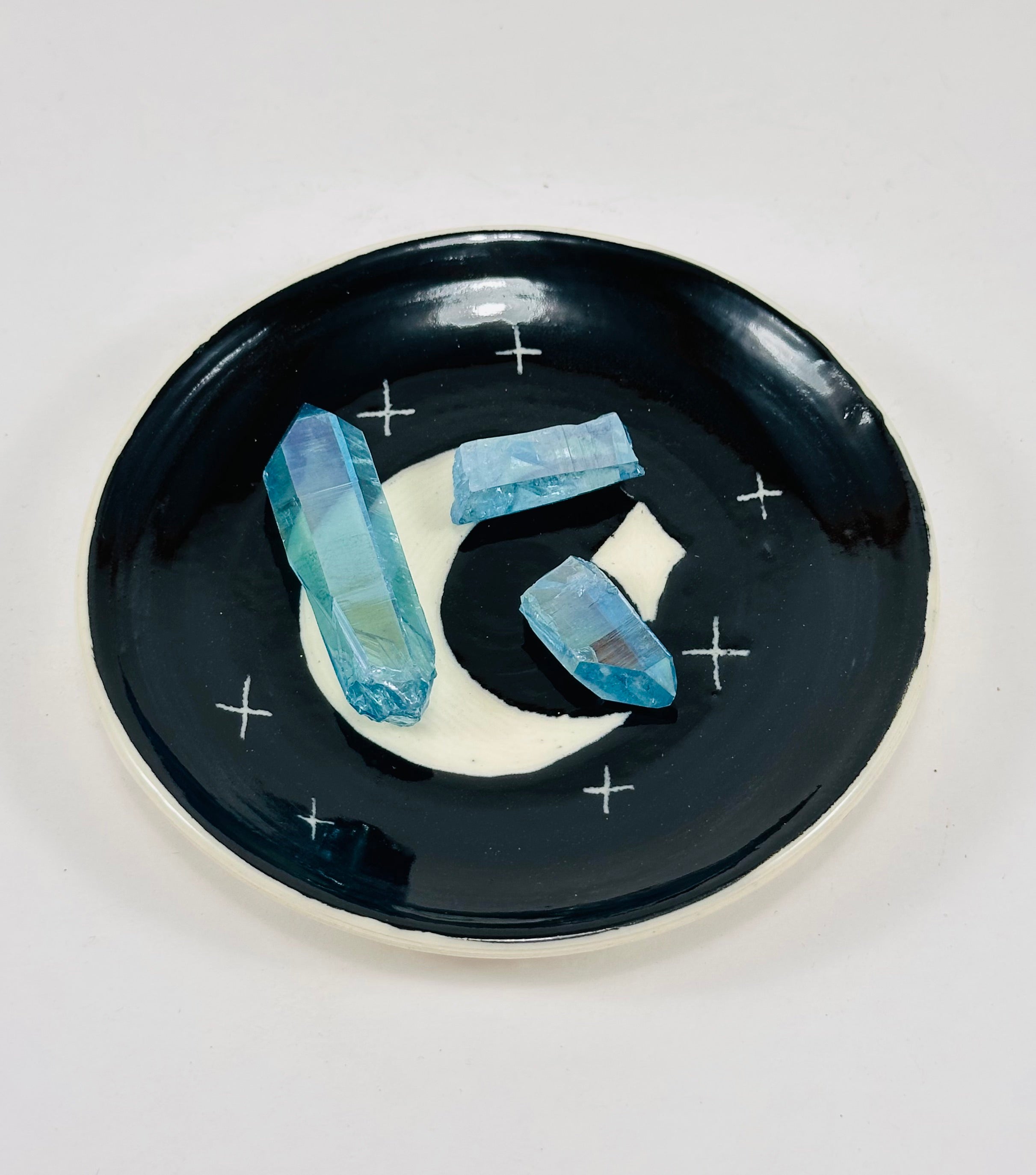 Handmade trinket dish in black and white glaze with moons and stars.