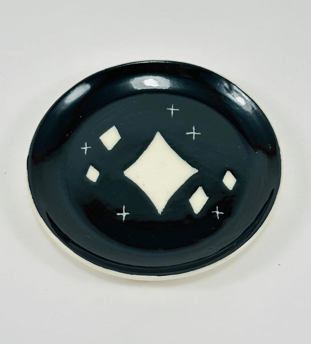 Handmade trinket dish in black and white glaze with stars.
