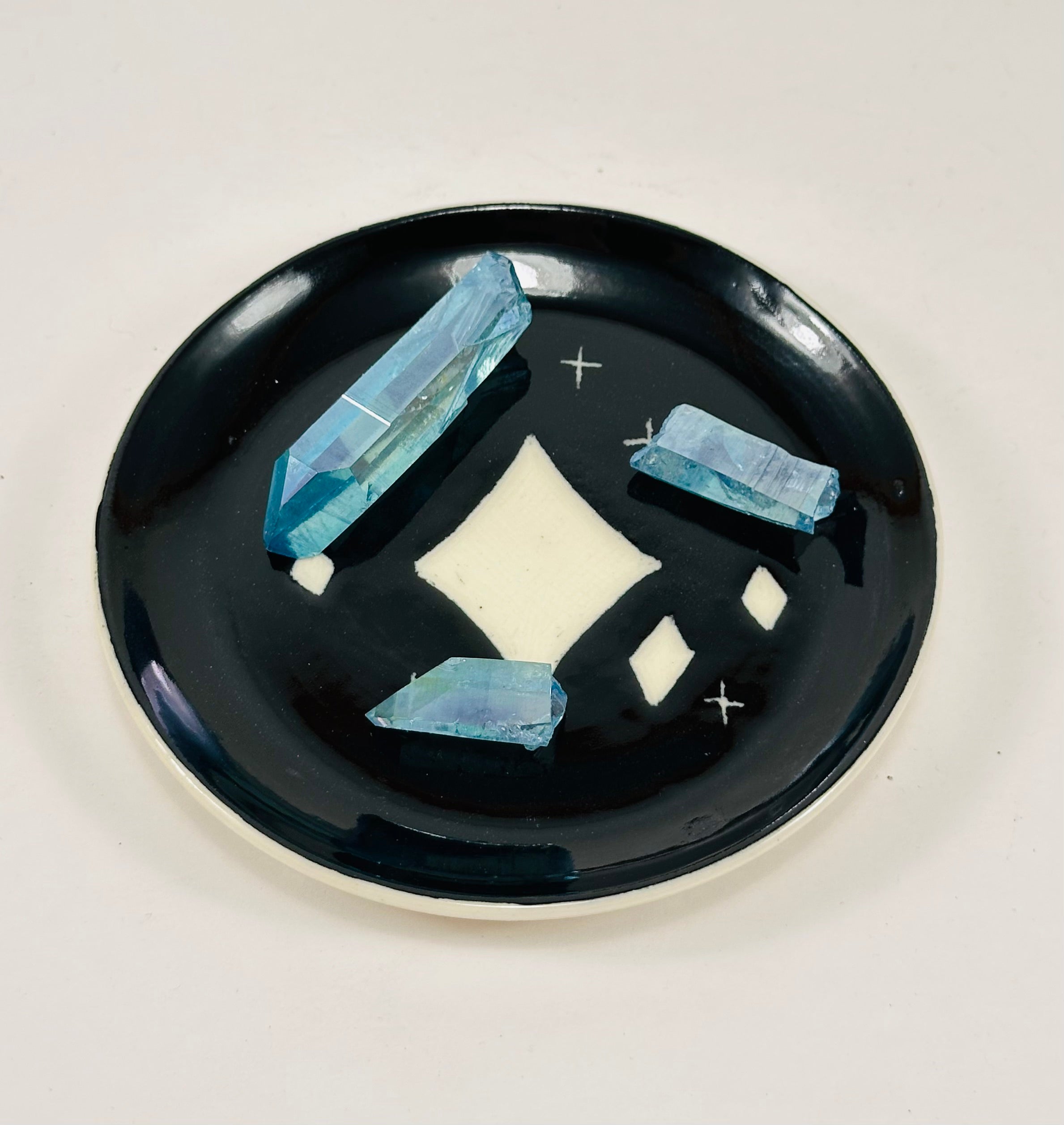 Handmade trinket dish in black and white glaze with stars.