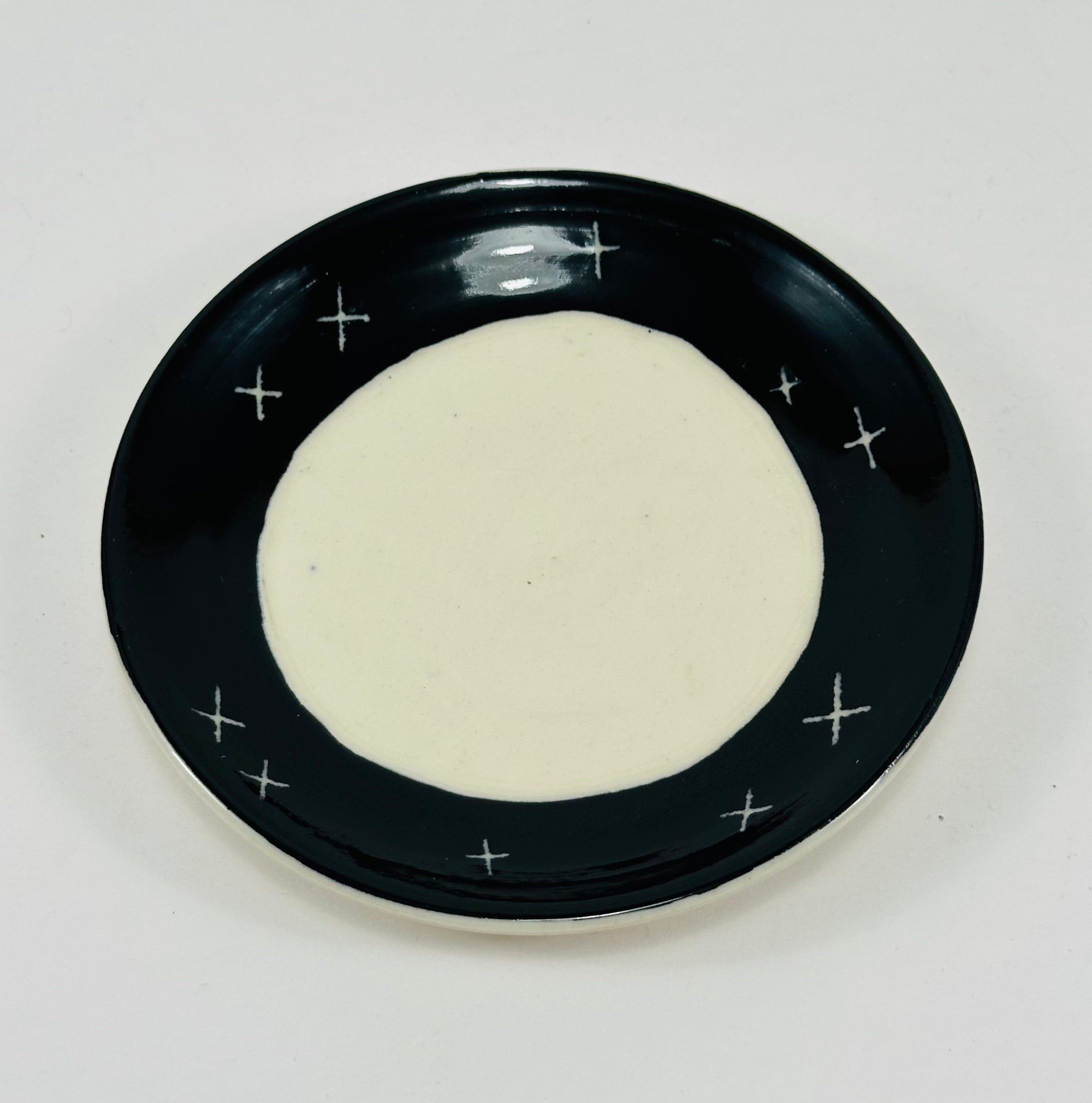 Handmade trinket dish in black and white glaze with stars and moon.