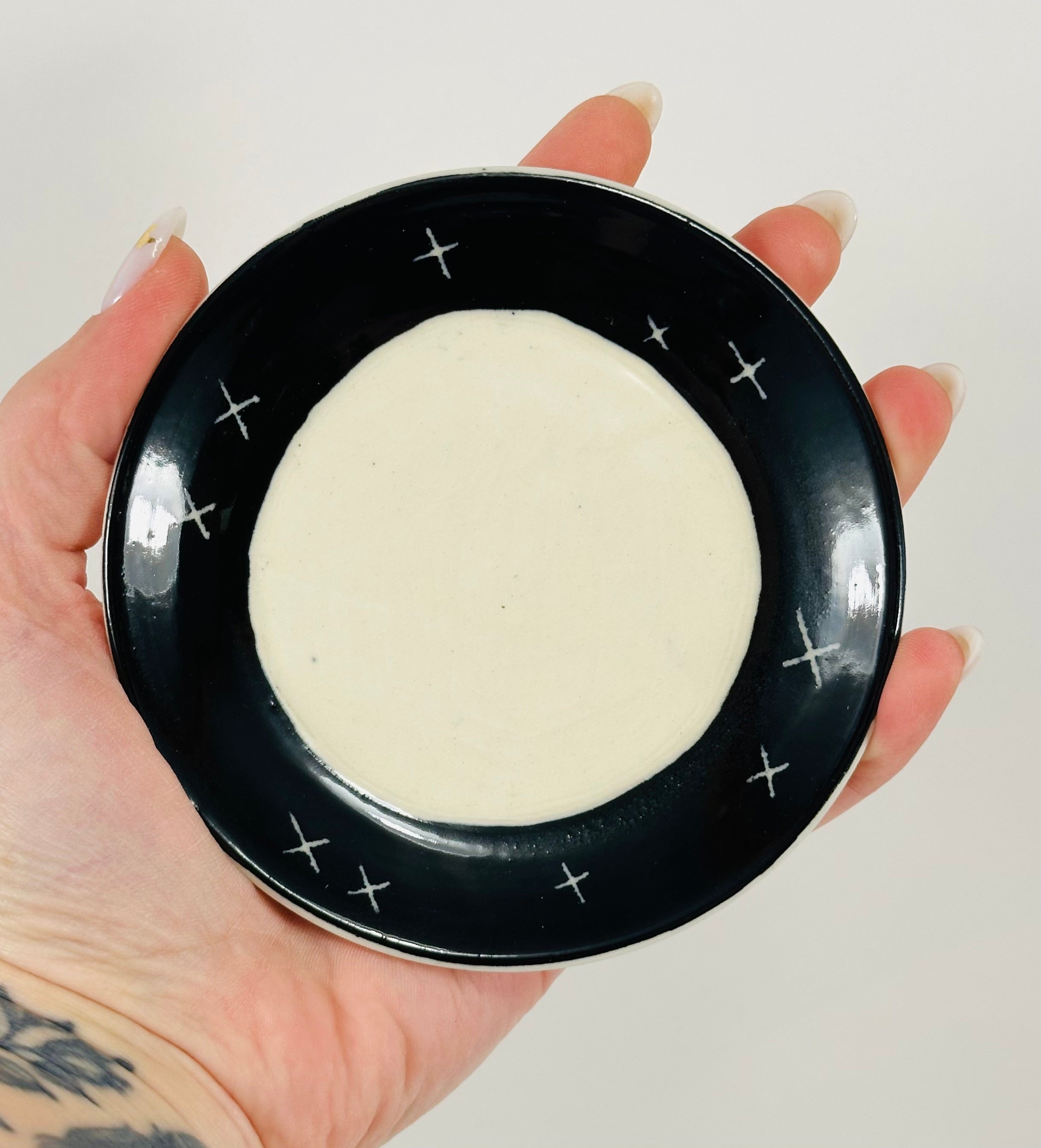 Handmade trinket dish in black and white glaze with stars and moon.