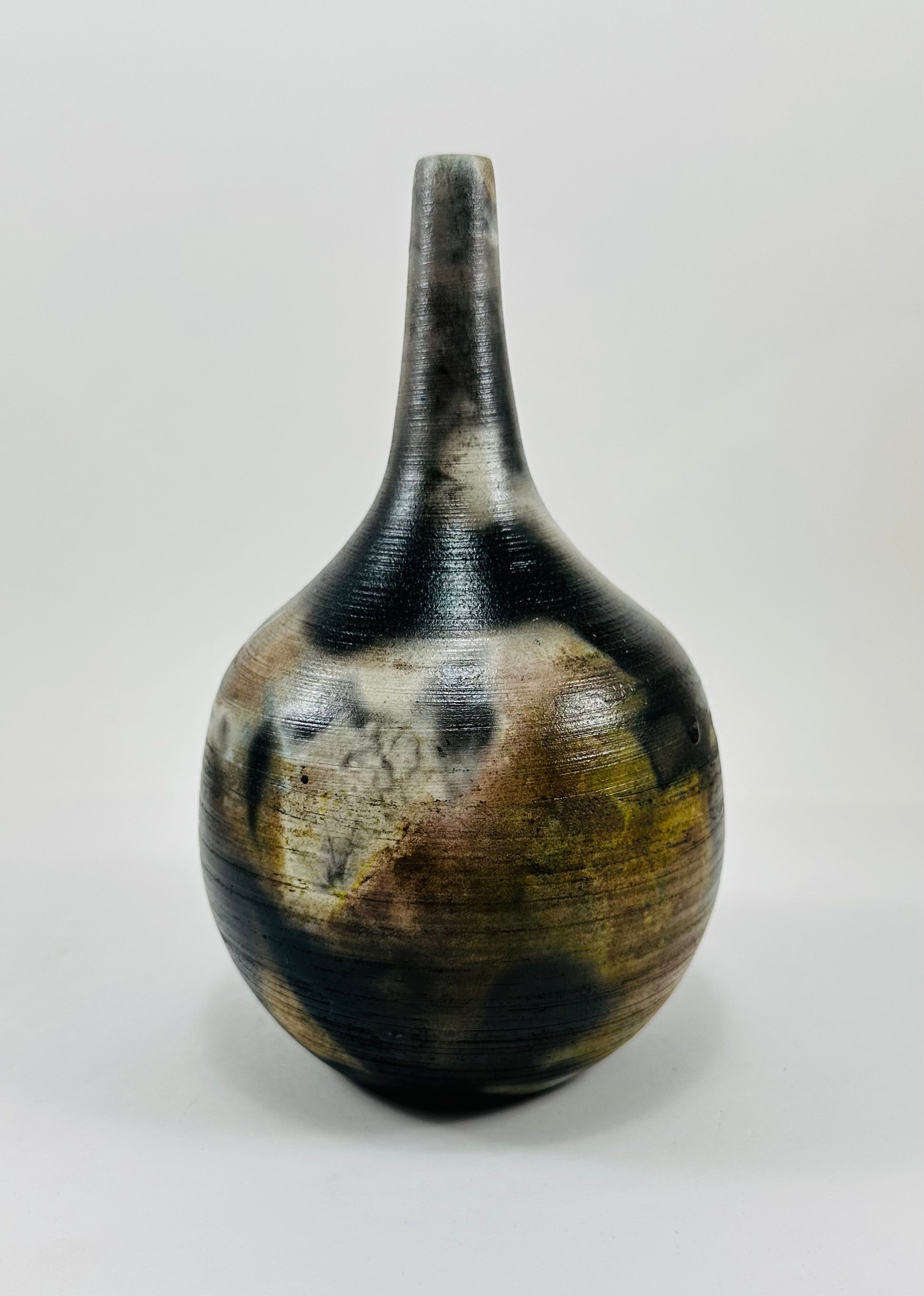 Handmade, skinny neck vase with a brown, white, black and yellow smokey finish.