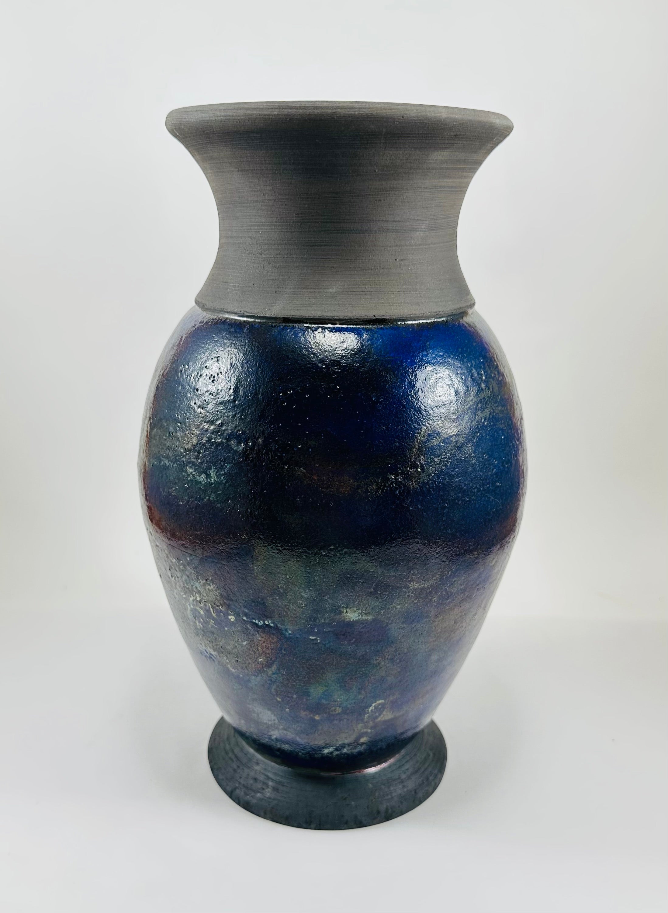 Handmade Raku vase in a beautiful purple glaze set against the raw, smokey black clay