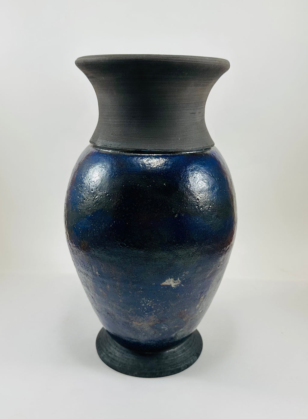 Handmade Raku vase in a beautiful purple glaze set against the raw, smokey black clay
