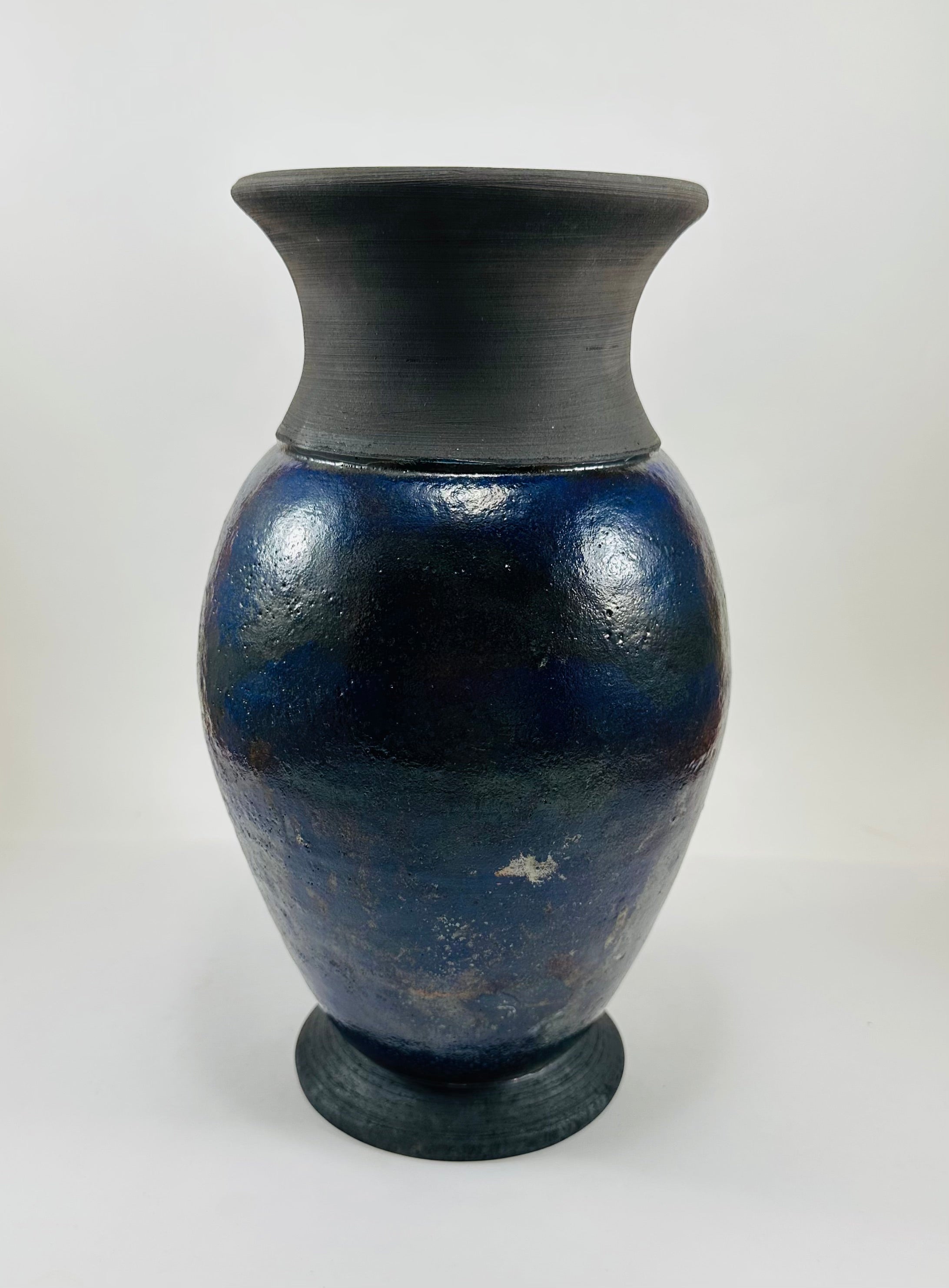 Handmade Raku vase in a beautiful purple glaze set against the raw, smokey black clay