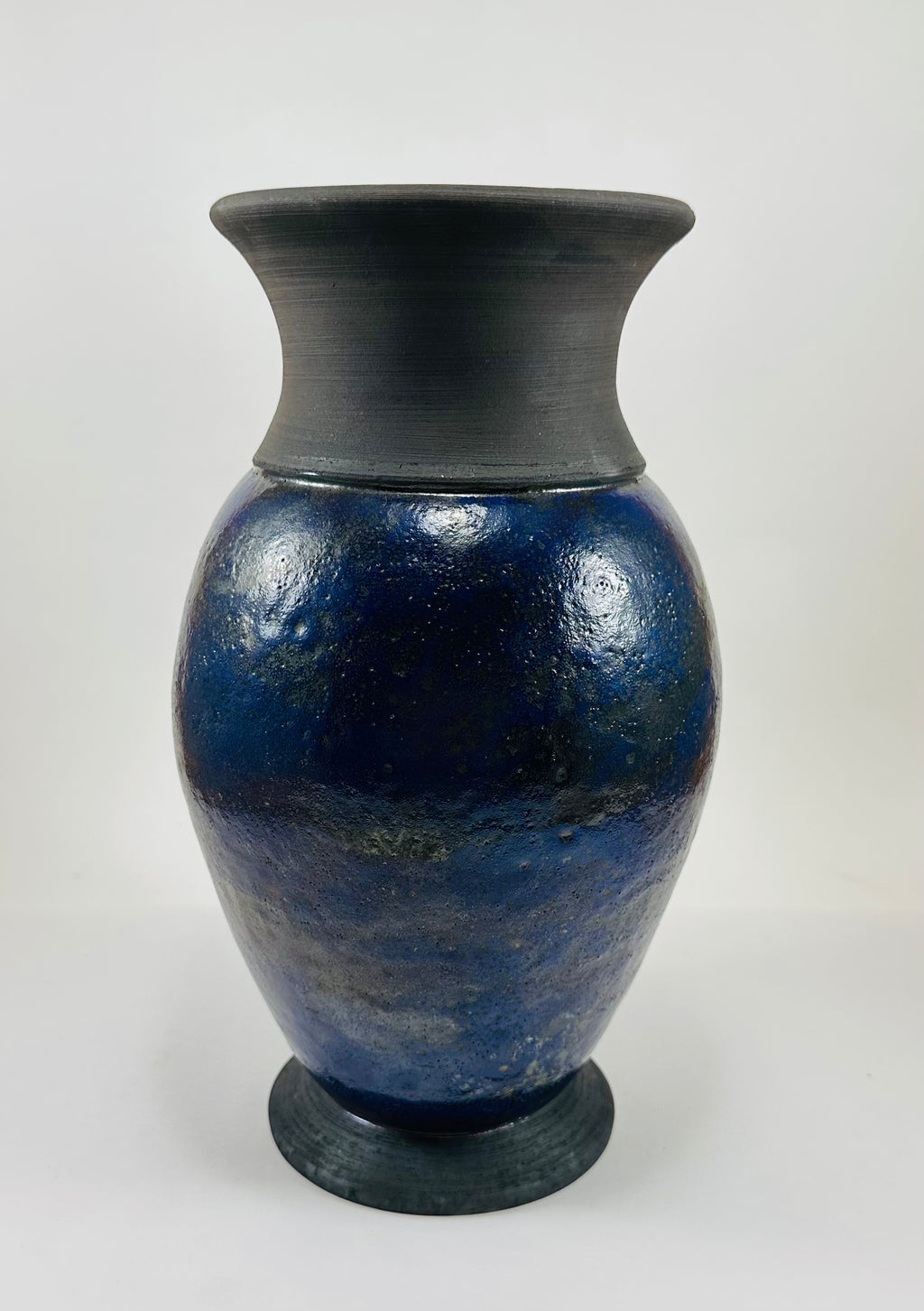 Handmade Raku vase in a beautiful purple glaze set against the raw, smokey black clay