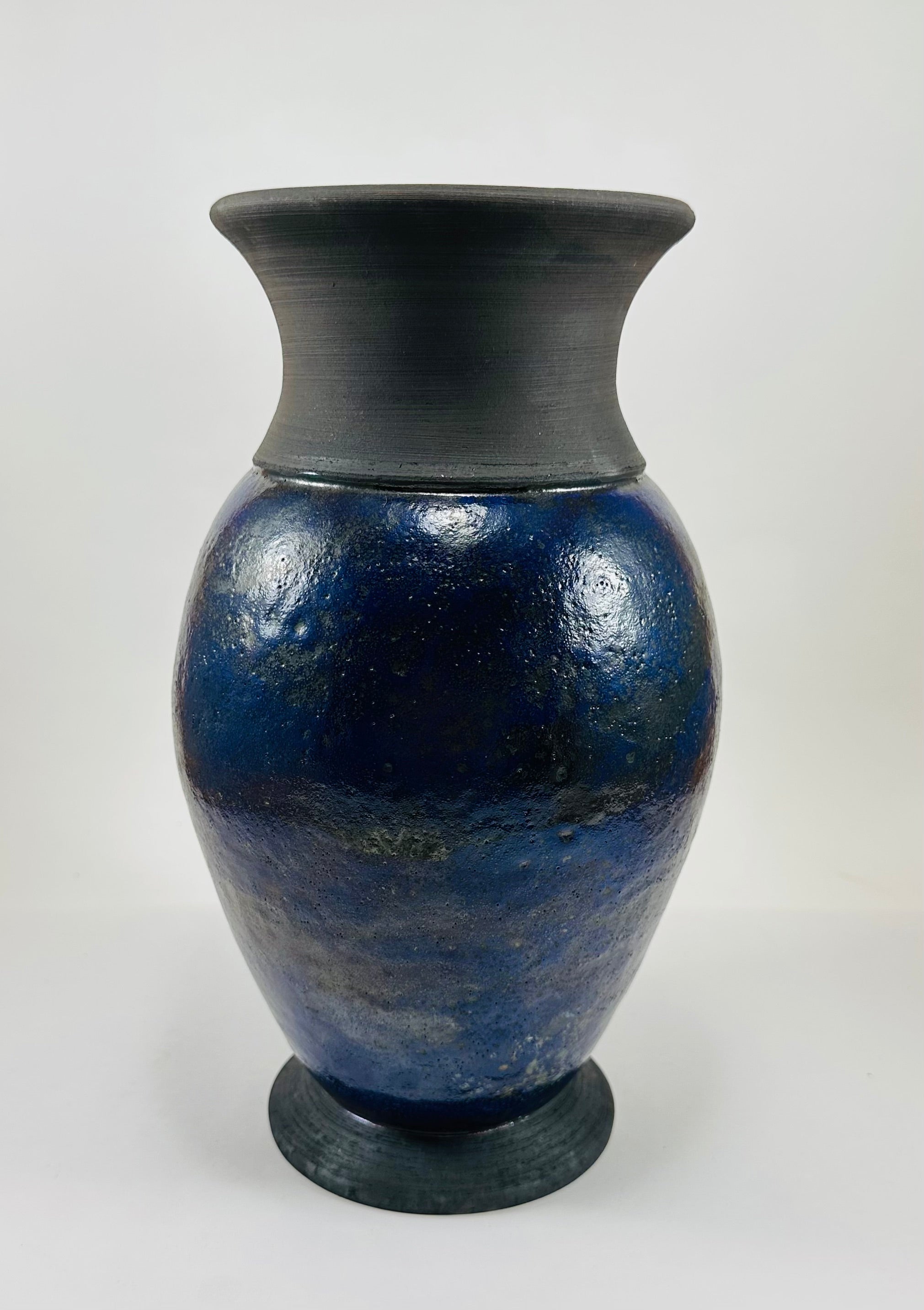 Handmade Raku vase in a beautiful purple glaze set against the raw, smokey black clay