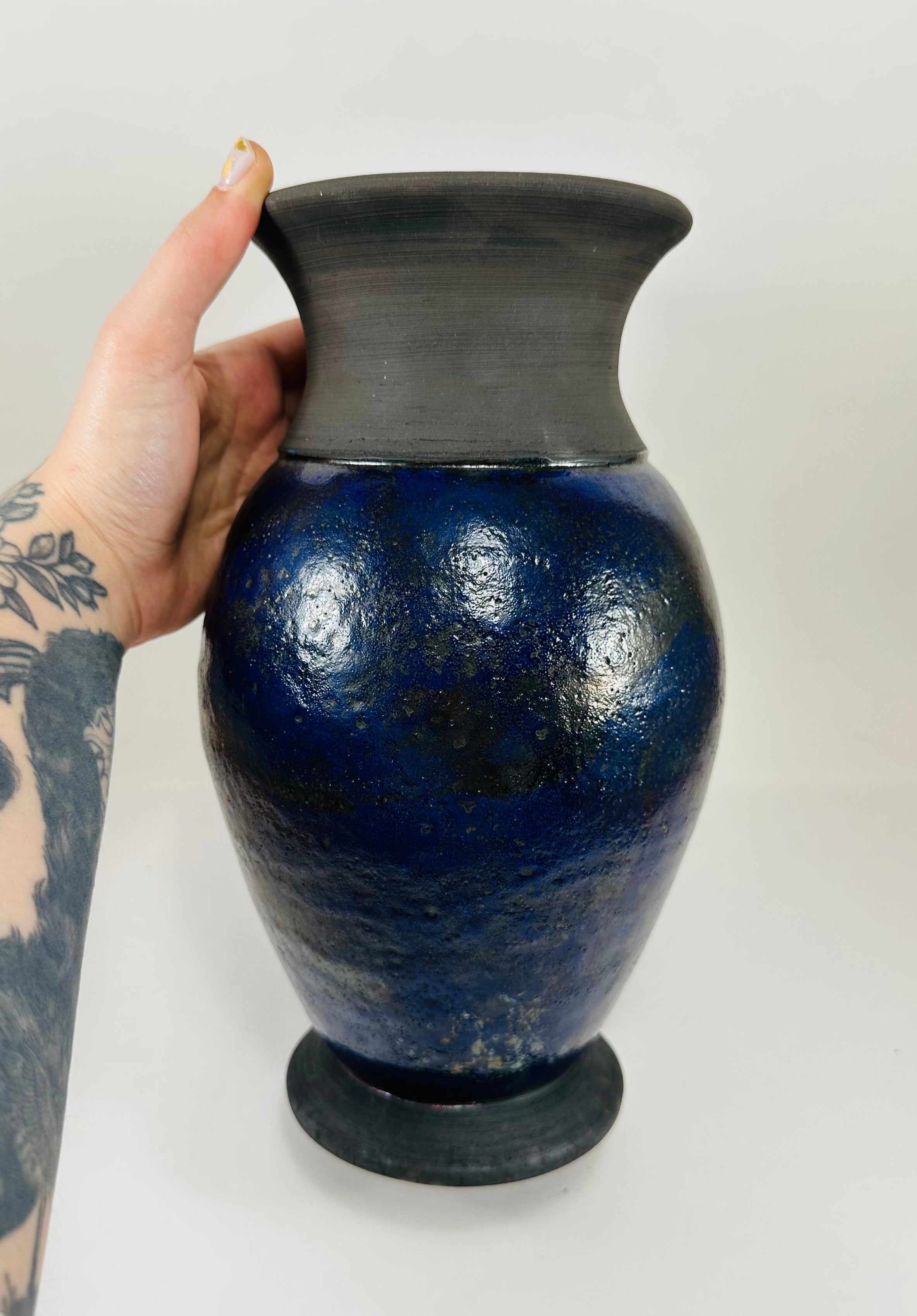 Handmade Raku vase in a beautiful purple glaze set against the raw, smokey black clay