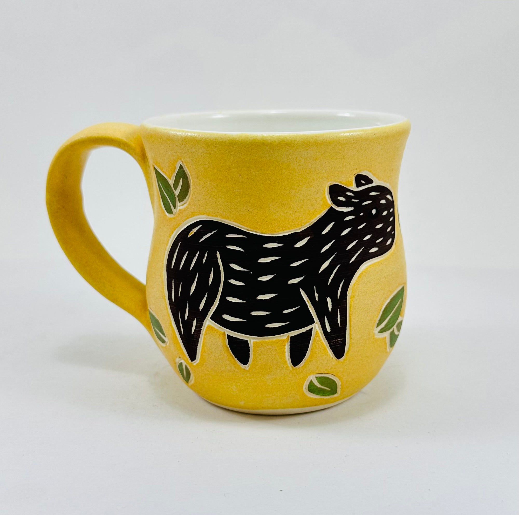 handmade ceramic mug in a beautiful yellow glaze with a capybara illustration on it