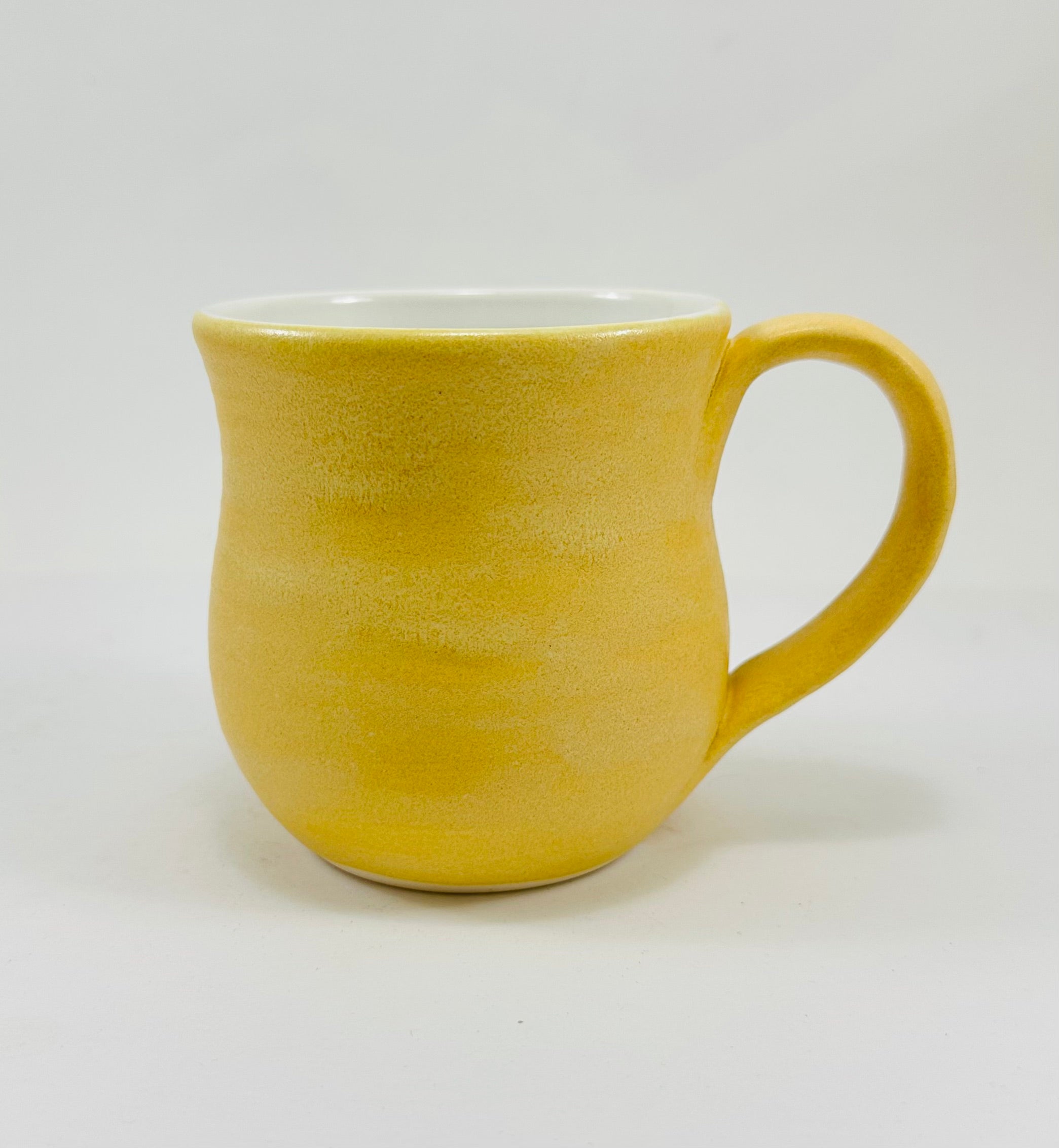 handmade ceramic mug in a beautiful yellow glaze with a capybara illustration on it