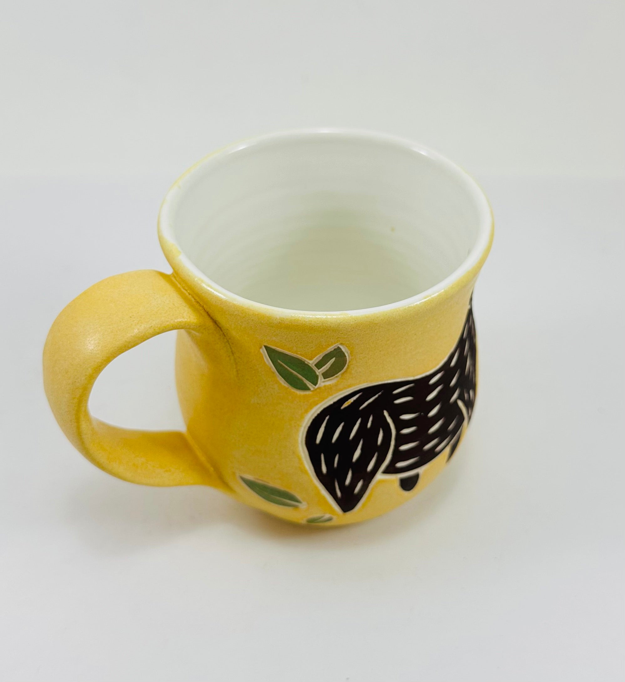 handmade ceramic mug in a beautiful yellow glaze with a capybara illustration on it