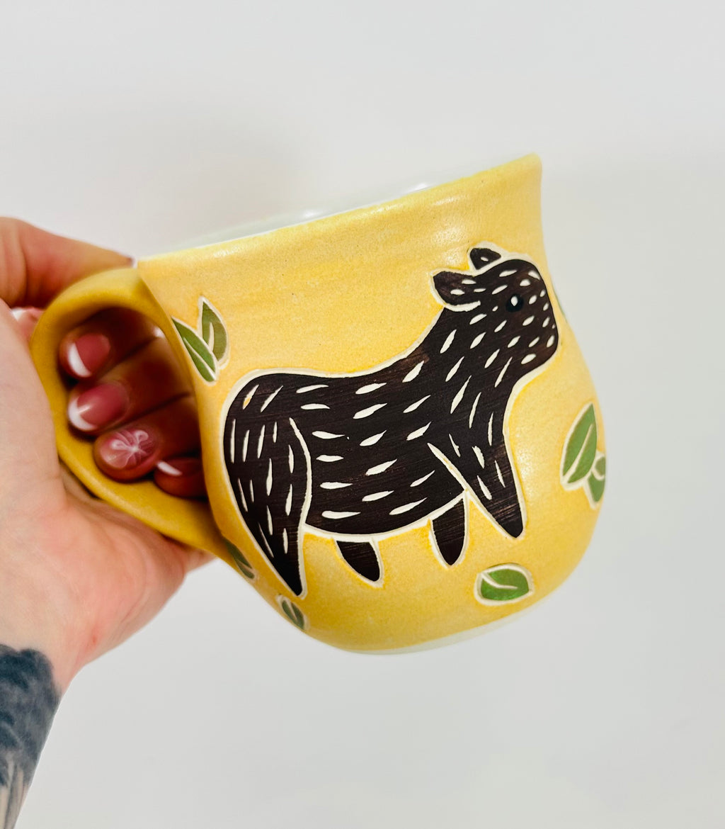 handmade ceramic mug in a beautiful yellow glaze with a capybara illustration on it