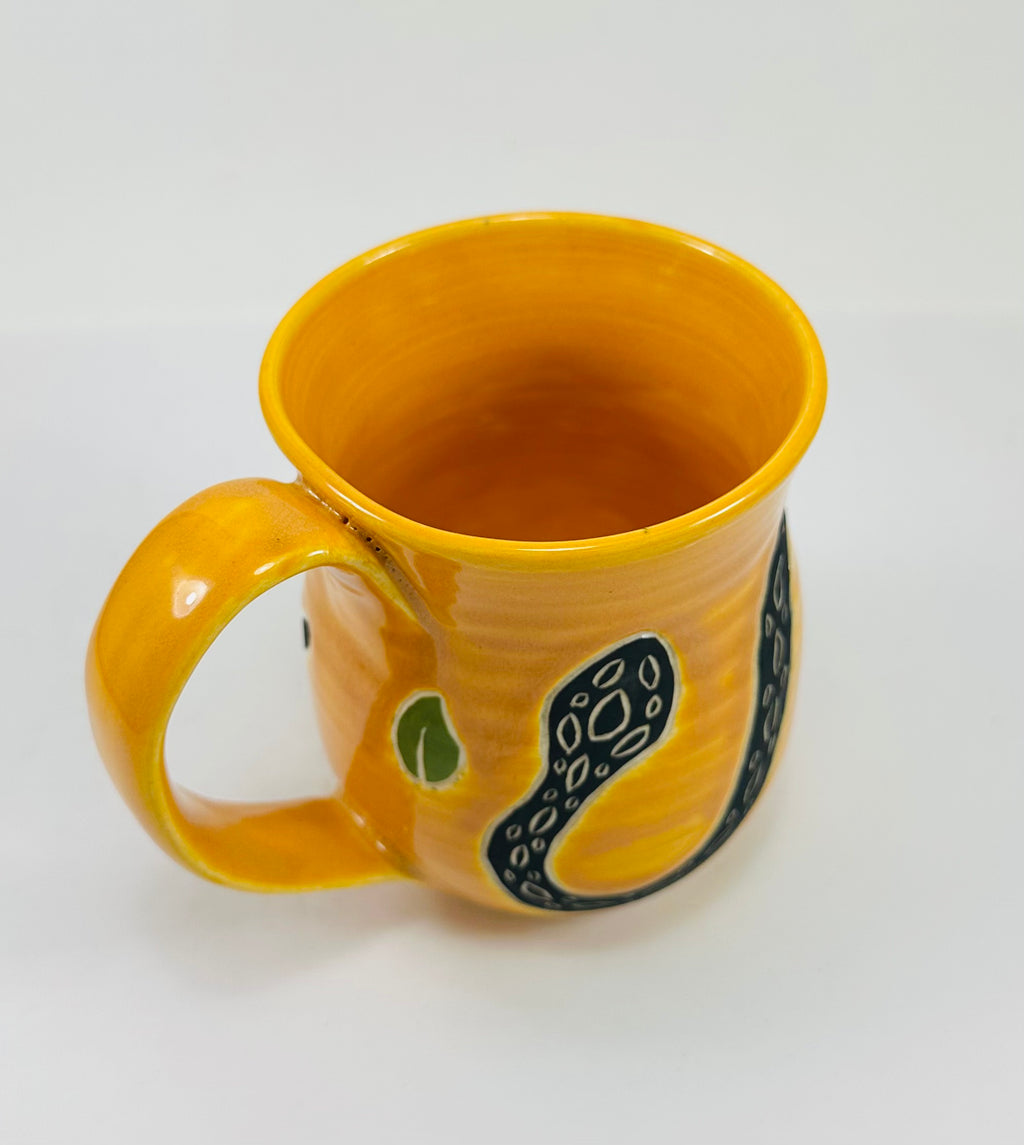 handmade ceramic mug in a beautiful yellow glaze with a snake on it