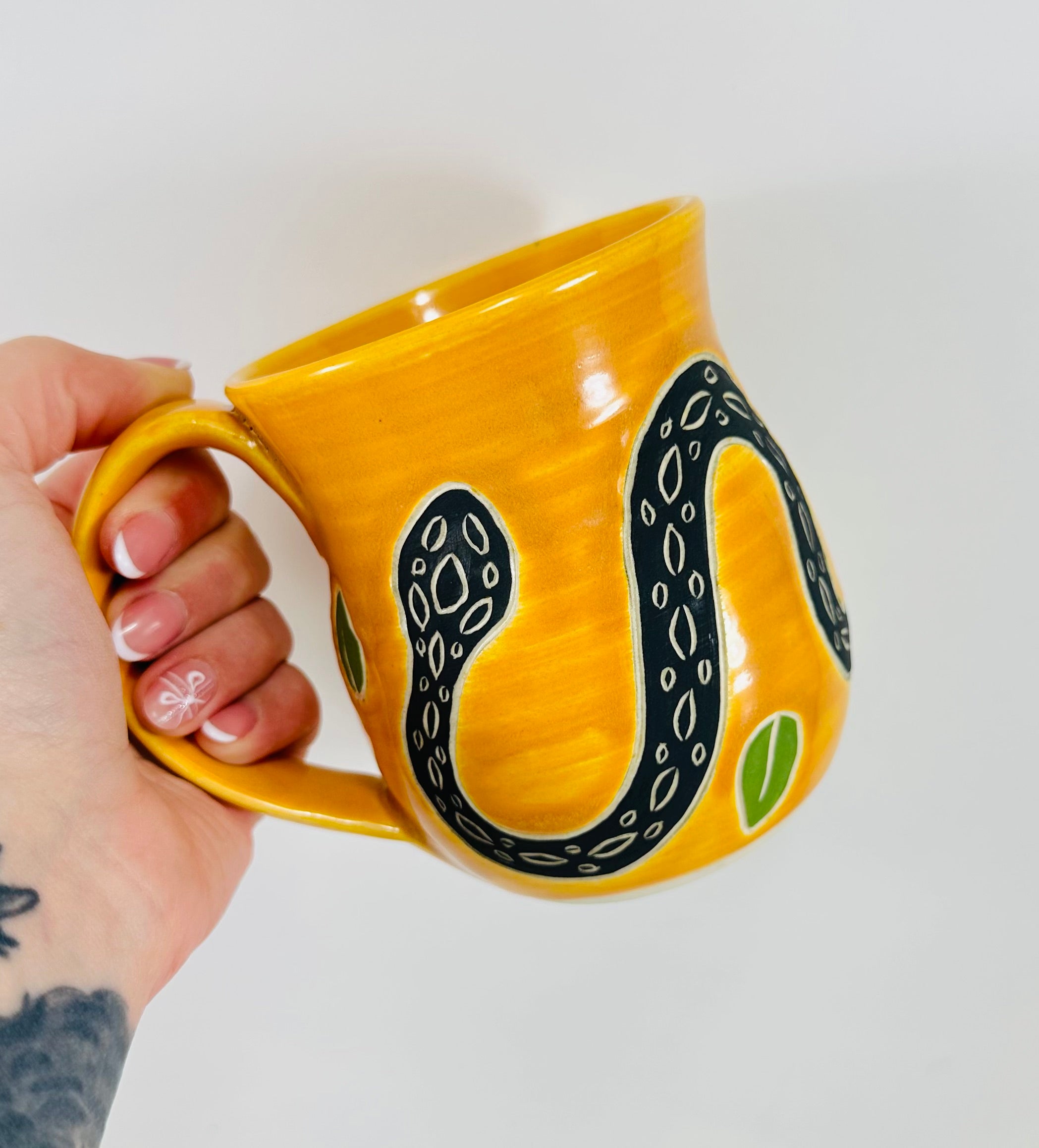 handmade ceramic mug in a beautiful yellow glaze with a snake on it