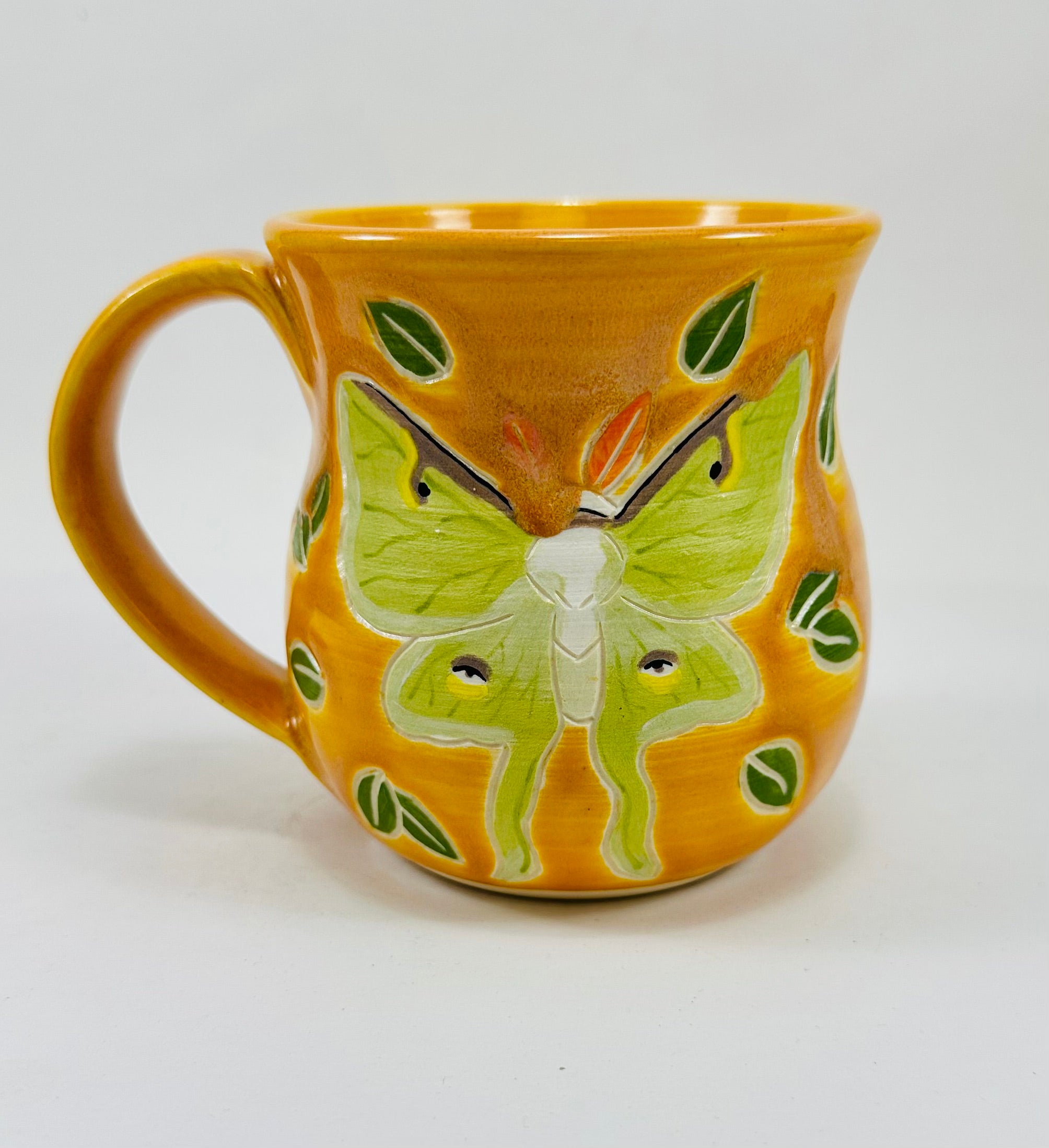 handmade ceramic mug in a beautiful yellow glaze and a luna moth illustration on it.