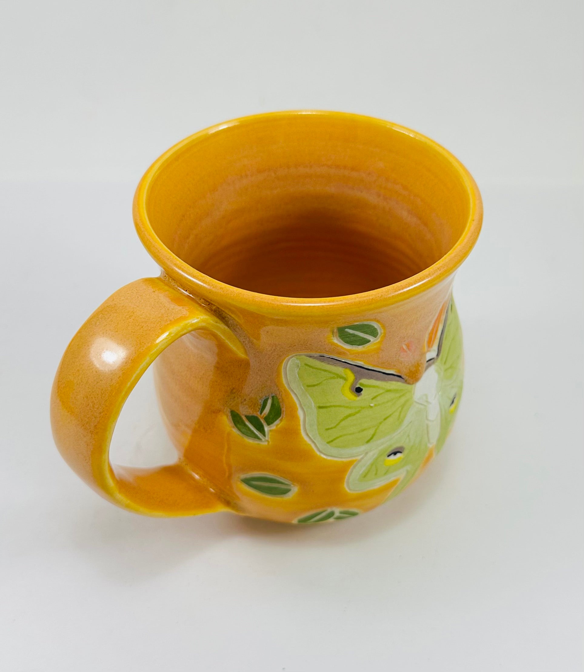 handmade ceramic mug in a beautiful yellow glaze and a luna moth illustration on it.