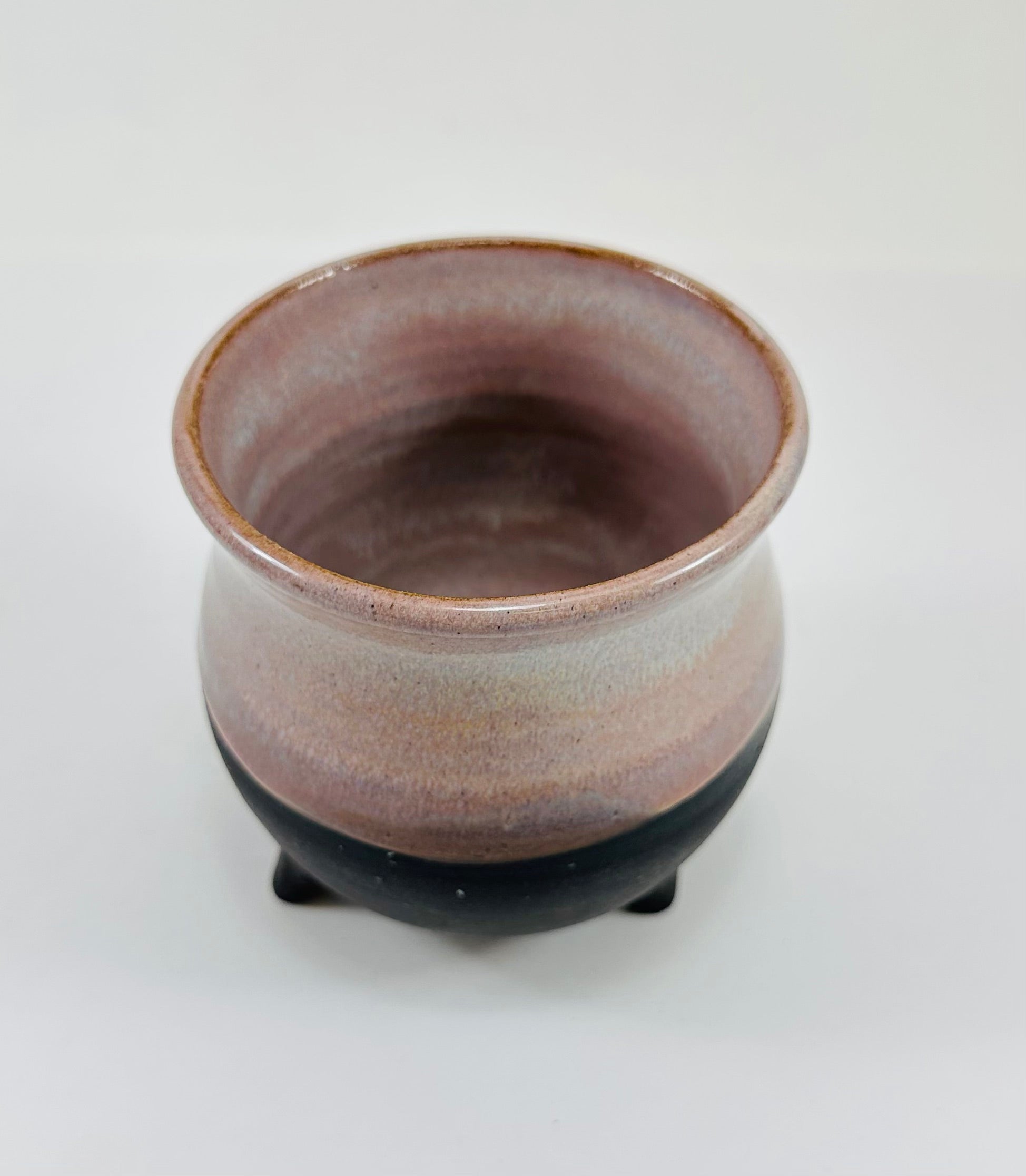 handmade ceramic cauldron mug on a beautiful purple and black glaze.