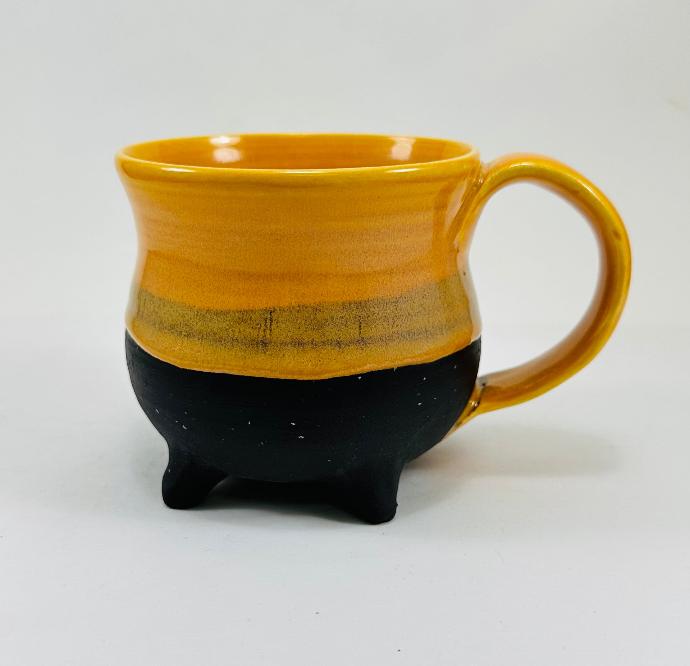 handmade ceramic cauldron mug in a beautiful yellow and black glaze