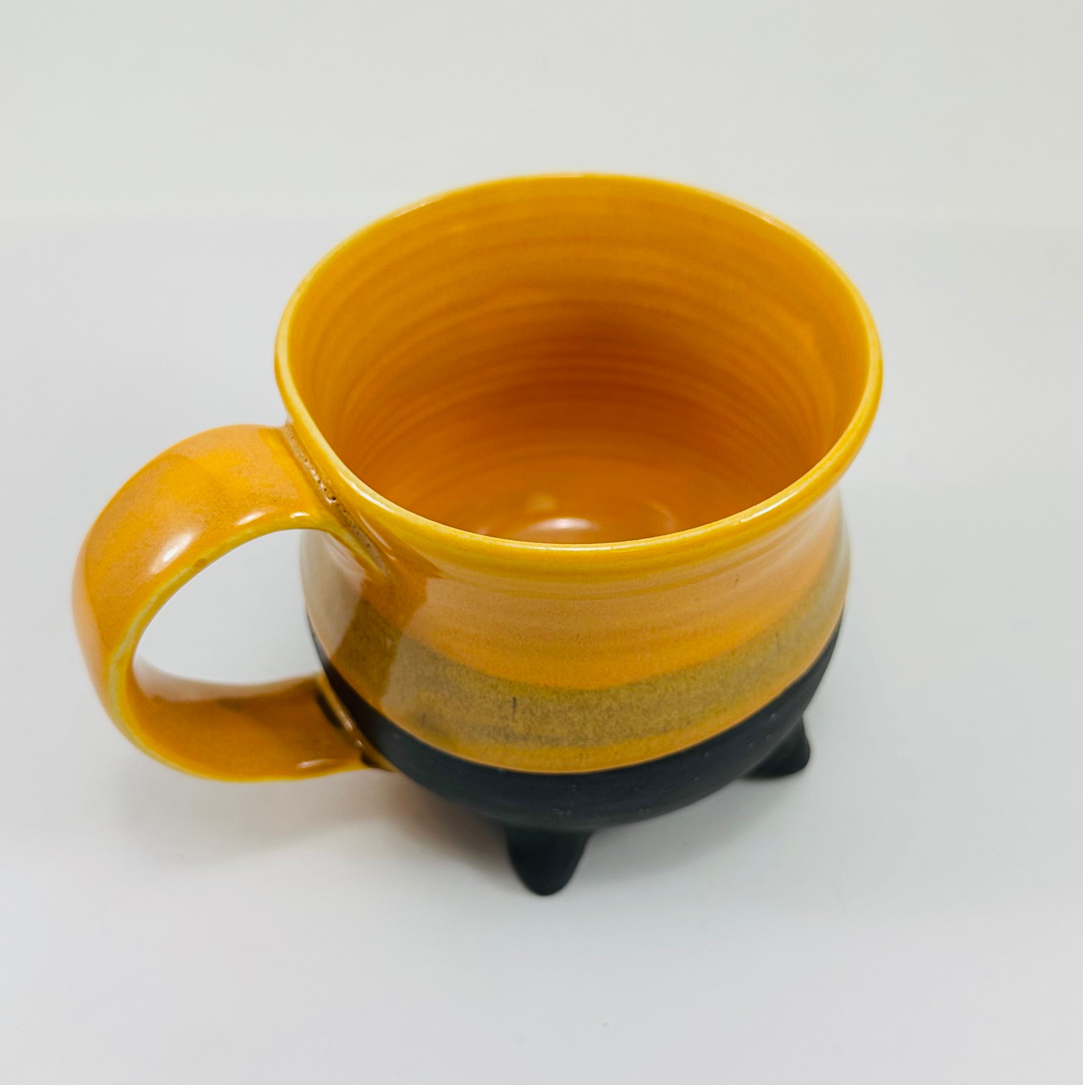 handmade ceramic cauldron mug in a beautiful yellow and black glaze