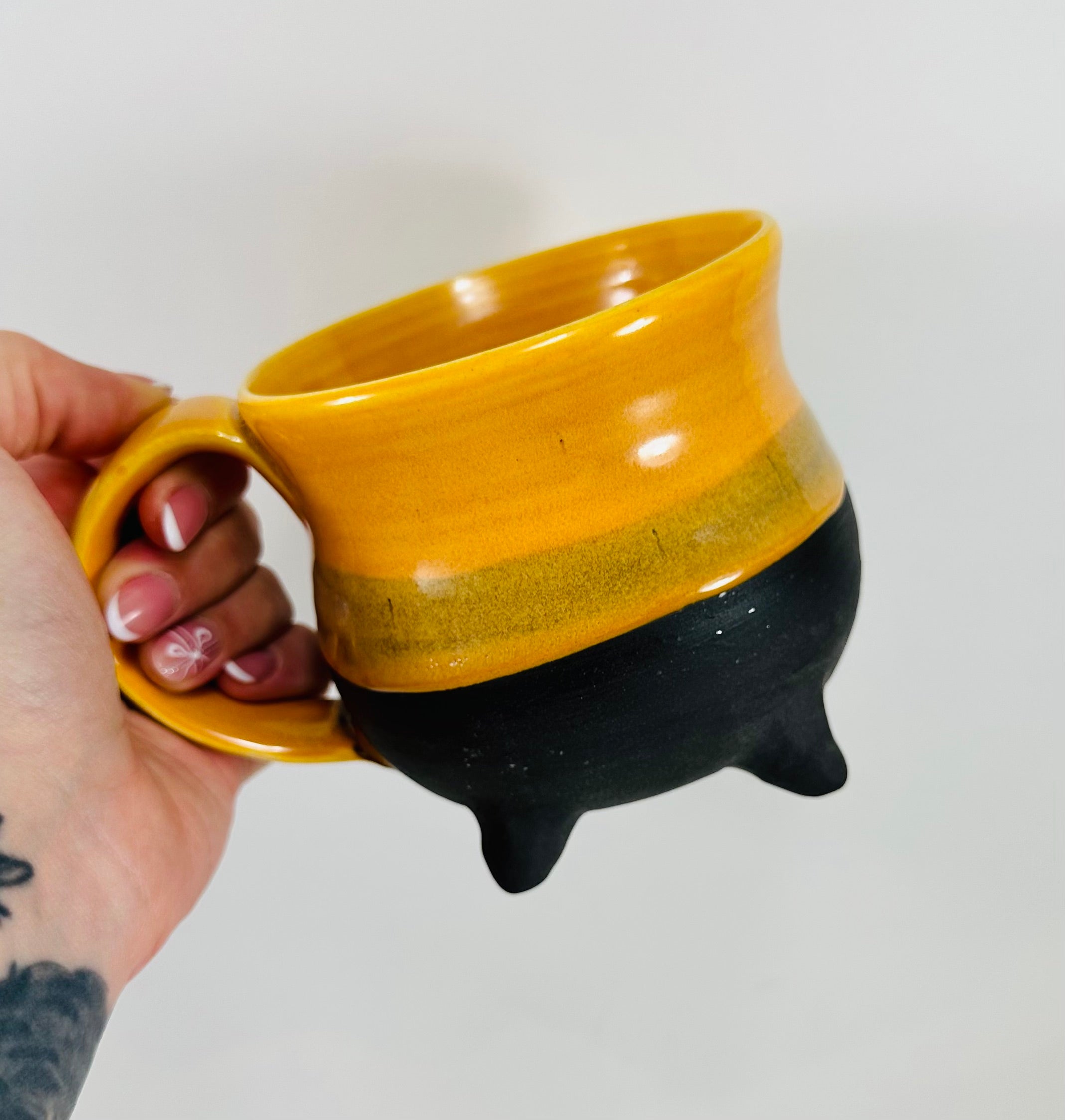 handmade ceramic cauldron mug in a beautiful yellow and black glaze