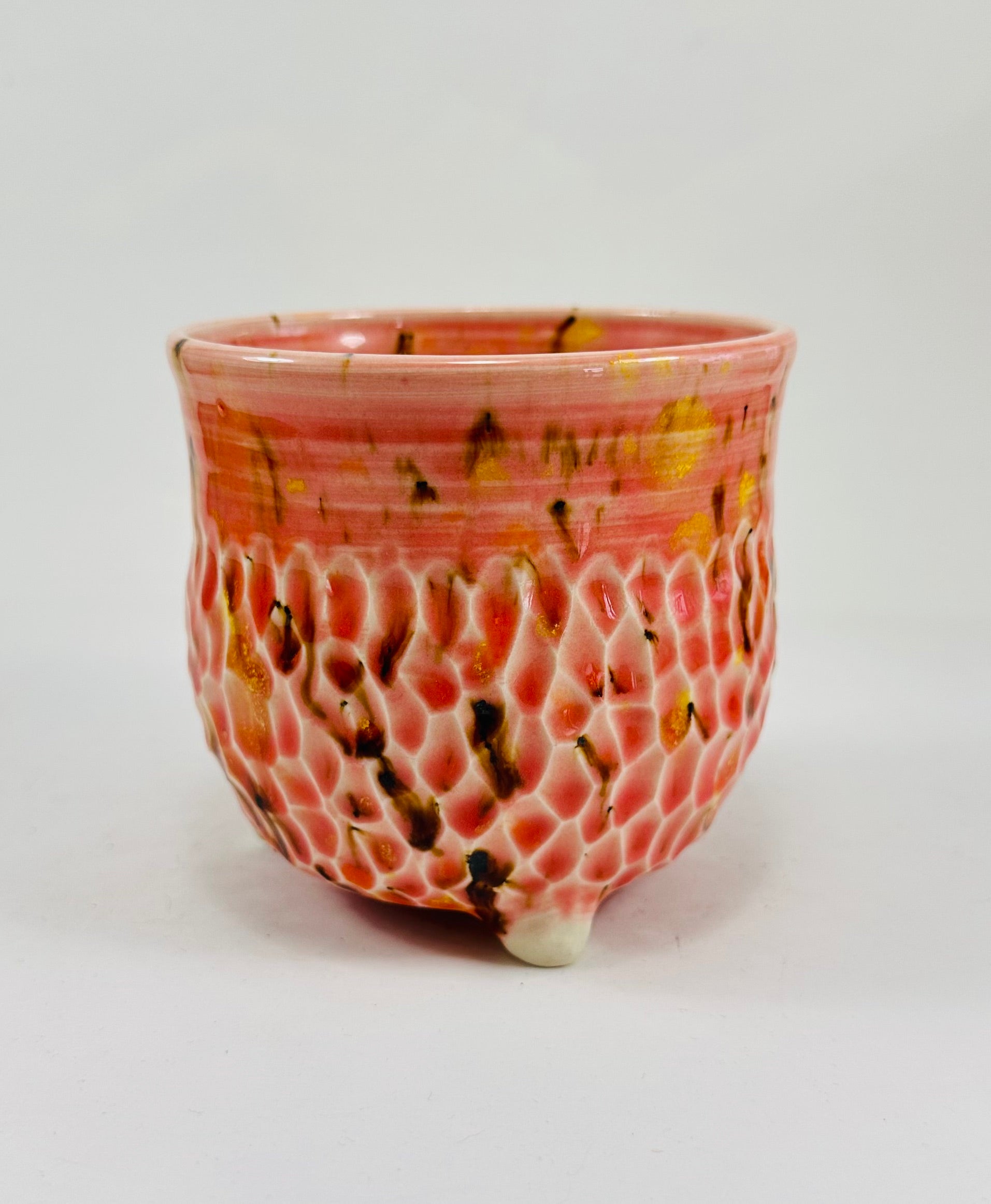 A handmade ceramic cauldron in a beautiful orange, yellow and brown glaze