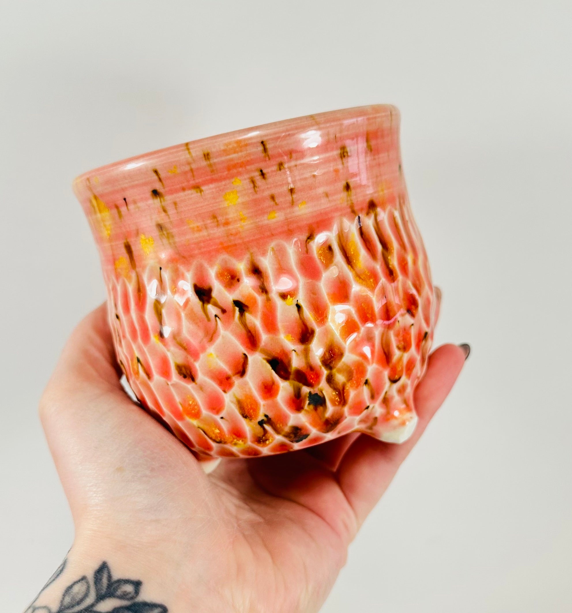 A handmade ceramic cauldron in a beautiful orange, yellow and brown glaze