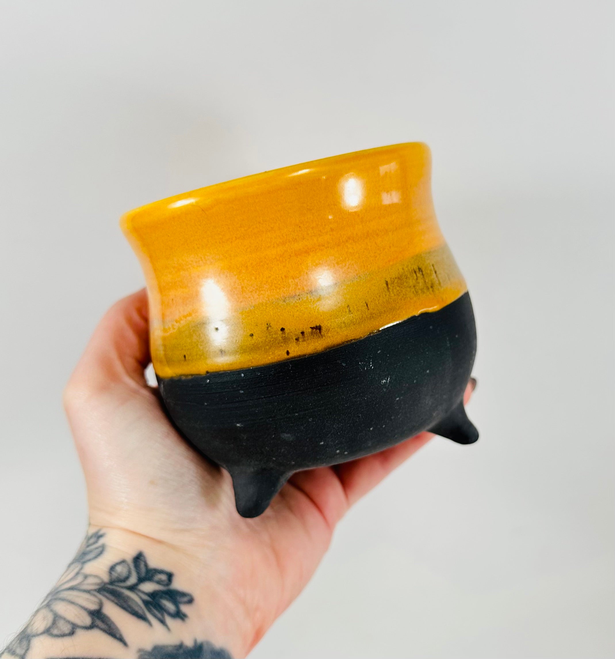 A handmade ceramic cauldron in a beautiful yellow and black glaze