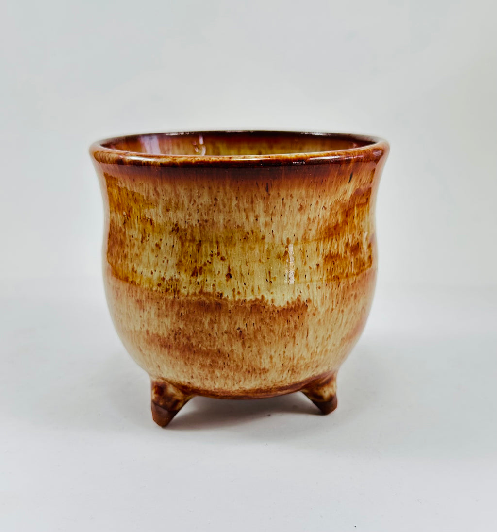 A handmade ceramic cauldron in a beautiful brown glaze