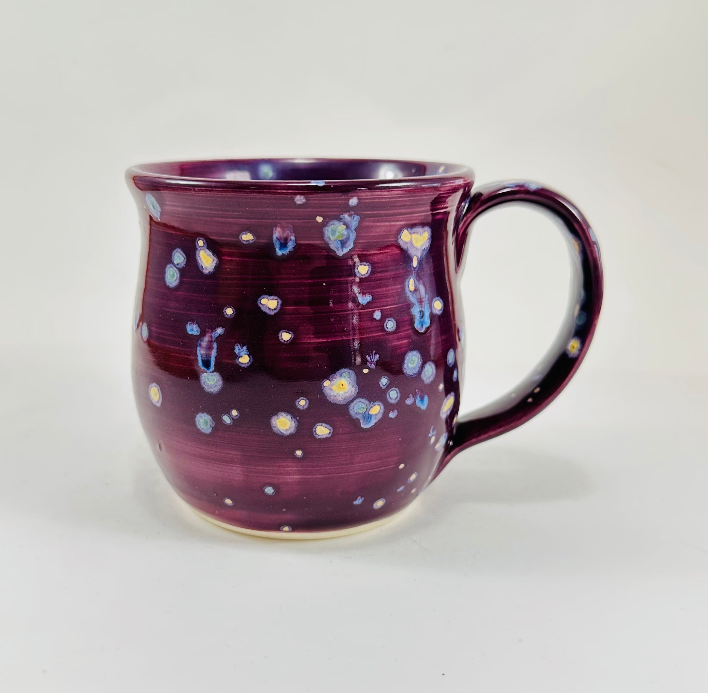 handmade ceramic mug in a beautiful purple glaze with a unicorn illustration on it